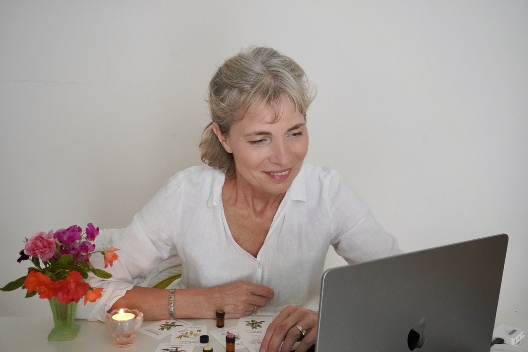 Corinna guiding a live online session, oils and cards on the table