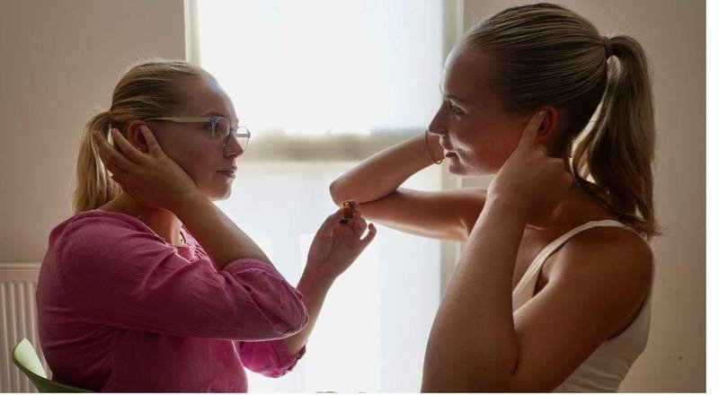 Applying oil to precise points behind the ears